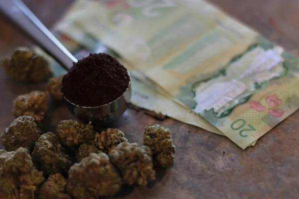 Cucharada de café junto a hierba o marihuana y billetes de veinte dólares —  Fotos de Stock