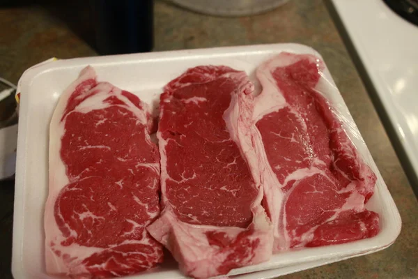 Friss nyers hátszín steak a fa fedélzetén fából készült háttérrel, sóval és borssal, rusztikus stílusban, felülnézet. — Stock Fotó