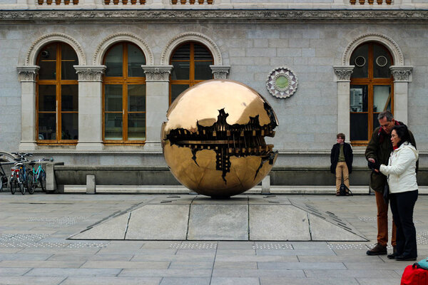 Dublin Ireland, February 18 2018: Editorial photo of tourists looking at the popular "sphere within a sphere"