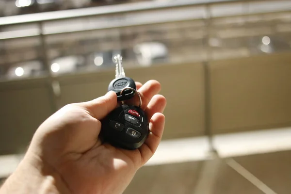 London Canada, March 5 2020: Editorial illustrative photo of someone holding a Chevrolet key towards parking lot. theme of starting car and driving — Stock Photo, Image