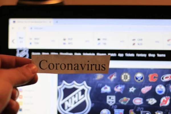 London Canada, March 12 2020: Editorial illustrative photo of coronavirus in front of the NHL website. The NHL has cancelled the season temporarily