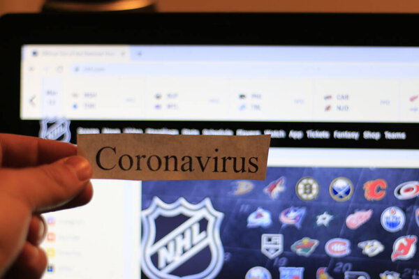 London Canada, March 12 2020: Editorial illustrative photo of coronavirus in front of the NHL website. The NHL has cancelled the season temporarily