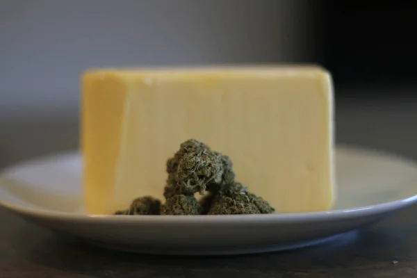 Cannabutter 'ın üretim süreci. Tereyağının önünde esrar tomurcukları