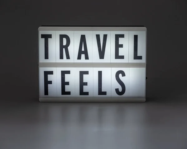 'TRAVEL FEELS' en caja de luz retro — Foto de Stock