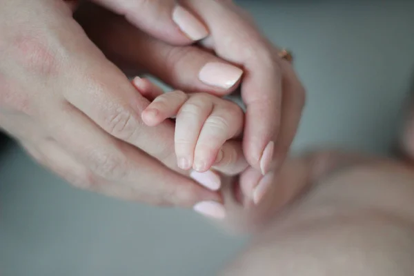 灰色の背景には、母親の手で子供の手 — ストックベクタ