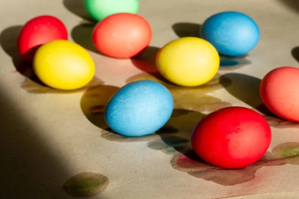 Set of wet-paint homemade colorful Easter eggs on parchment paper. Spring holiday symbols. Christian gift.