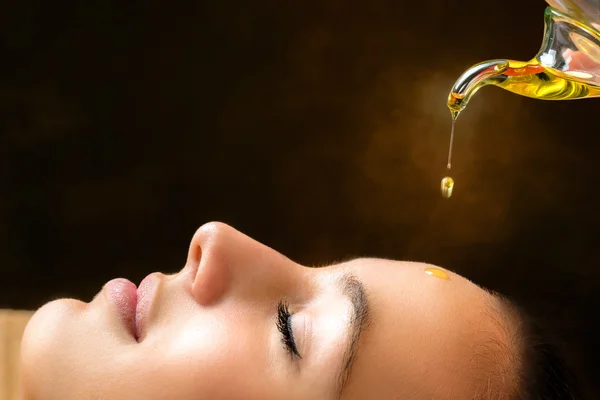Aromatische olie druipend op vrouwelijke gezicht. — Stockfoto