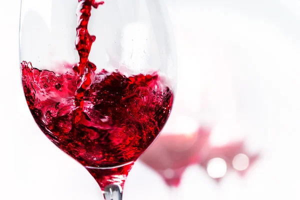 Macro close up of red wine pouring in to glass. — Stock fotografie