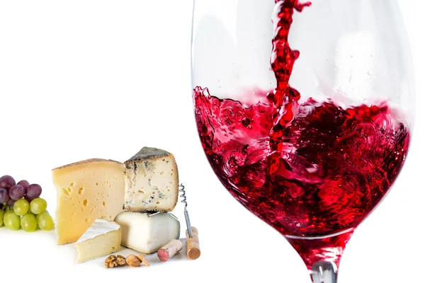 Pouring red wine in glass with cheese — Stock fotografie