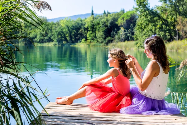 Meisjes ontspannen naast lake. — Stockfoto