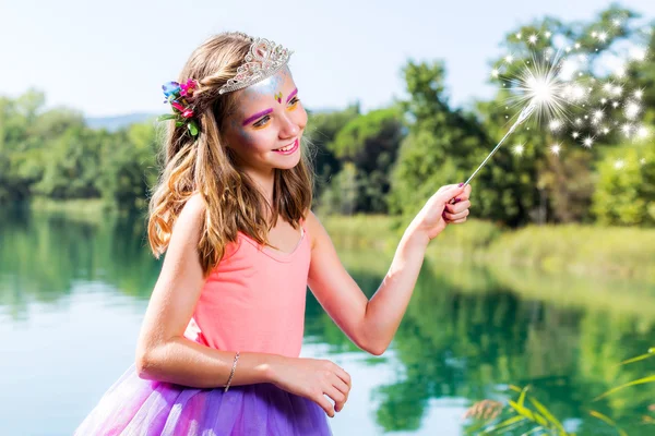 Девушка играет с волшебной палочкой на озере — стоковое фото