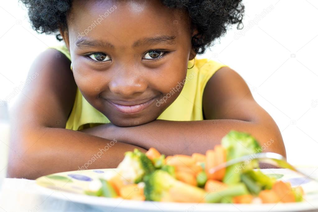 cute little african girl with vegetables 