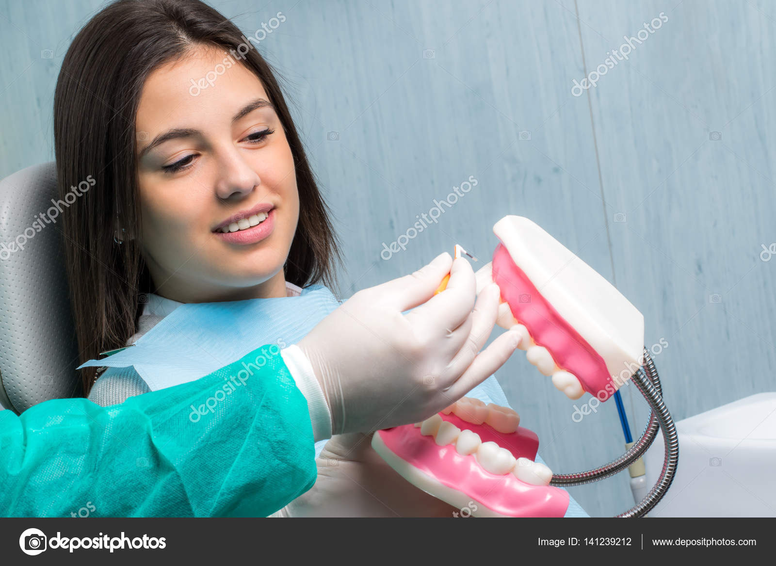 Dentist showing patient interdental cleaning Stock Photo by ©karelnoppe