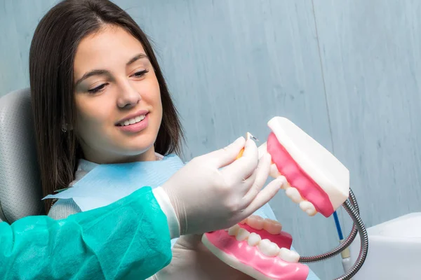 Zubař ukazující pacienta mezizubní čištění — Stock fotografie