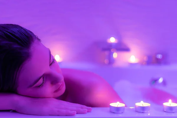 Woman in foam bath with candles — Stock Photo, Image
