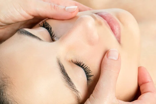 Mains faisant massage facial — Photo