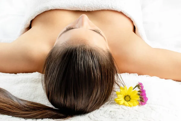 Frau liegt auf Massagebett im Wellnessbereich — Stockfoto