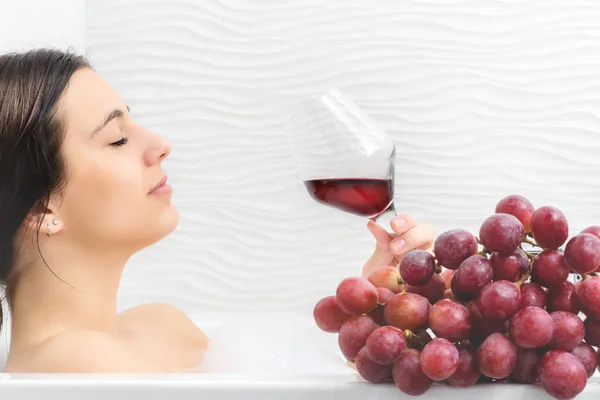 Mulher relaxante no banho com vinho — Fotografia de Stock