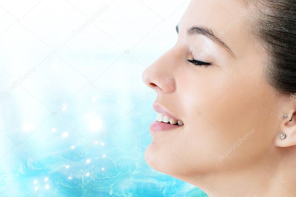 woman meditating against blue water