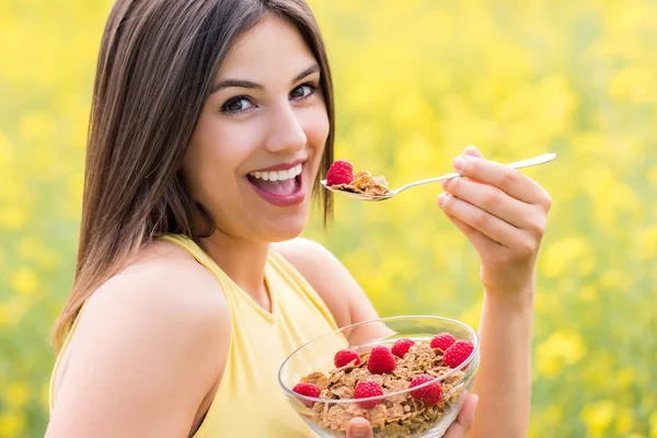 Cute girl eating healthy cereal breakfast outdoors. — Stock Photo, Image