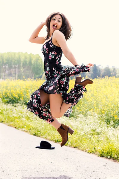 Menina feliz em vestido de flor pulando ao ar livre . — Fotografia de Stock