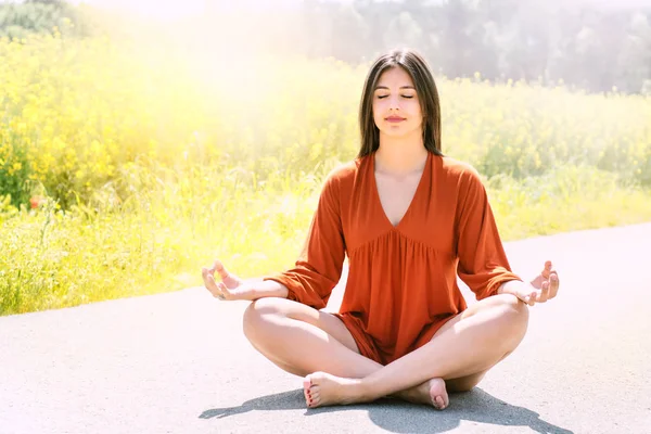 Kız çiçek alanında meditasyon. — Stok fotoğraf