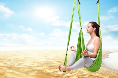 Anti yerçekimi yoga hamakta oturan kadın