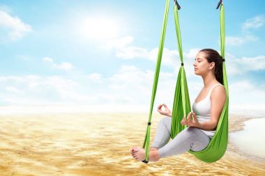 woman sitting in antigravity yoga hammock clipart