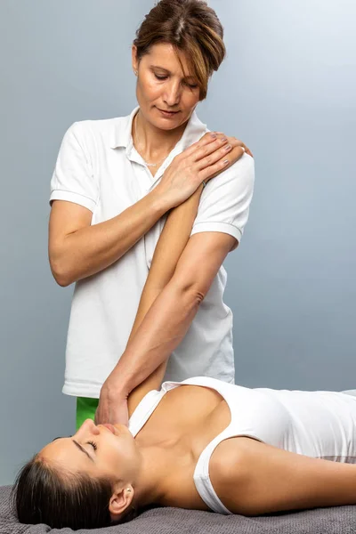 Ženské osteopat manipulaci s ramenem na pacienta. — Stock fotografie