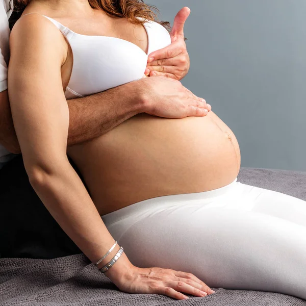 Hands doing abdomen massage on pregnant belly. — Stock Photo, Image