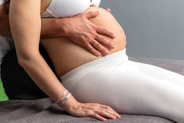 Therapist applying pressure on pregnant belly. — Stock Photo, Image
