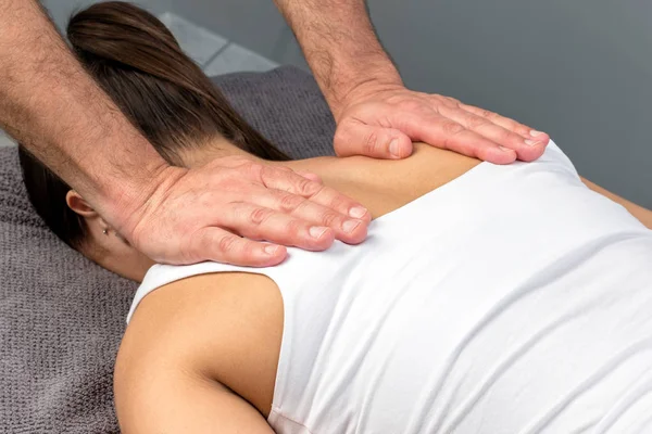 Therapist hands applying pressure on female shoulder blades. — Stock Photo, Image