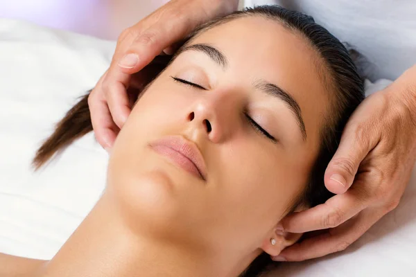 Terapeuta massageando o lado das orelhas femininas . — Fotografia de Stock