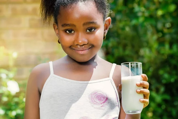 Afrikanisches Kind hält Glas mit Milch im Freien. — Stockfoto