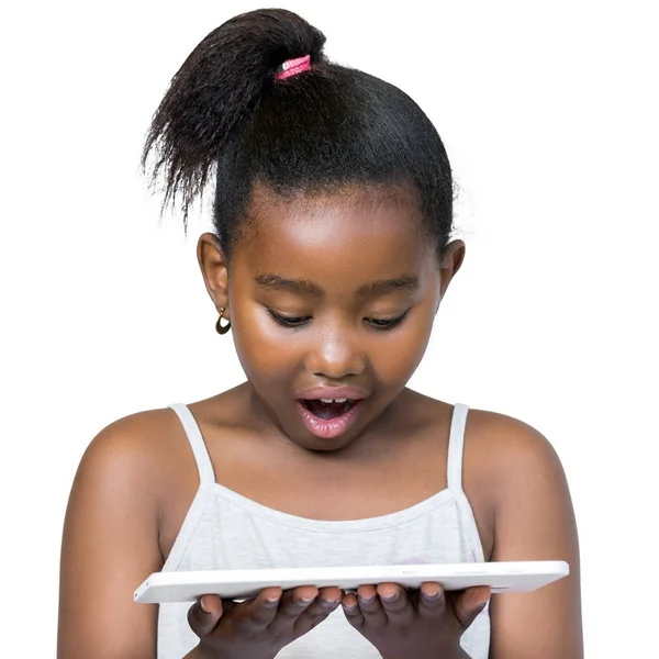 Afrikaanse meisje op zoek naar een tablet met verbaasd gezicht expr — Stockfoto