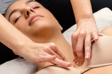 Close up portrait of woman having kinesiological therapy. Hands applying pressure on chest. clipart