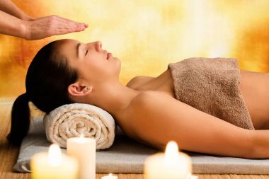 Ruhsal aydınlanma reiki terapi kadın portresi kapatın. Mum ışığı, başının üstünde elleriyle terapist.