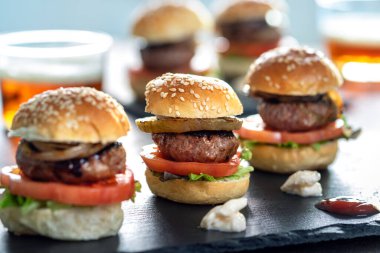 Close up of appetizing mini beef hamburgers on at catering event. clipart