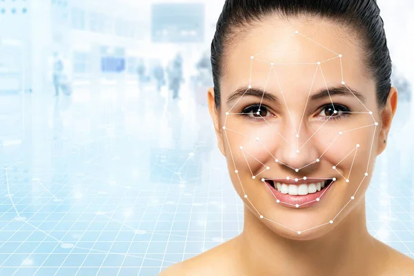 Close up portrait of attractive caucasian woman with facial recognition technology. Grid with reference areas marked on face. Young girl against out of focus airport background.