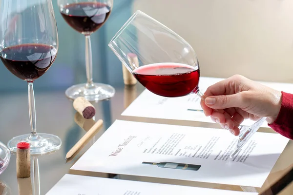 Κοντινό Πλάνο Του Enologist Κρατώντας Κόκκινο Ποτήρι Κρασιού Στο Τραπέζι — Φωτογραφία Αρχείου