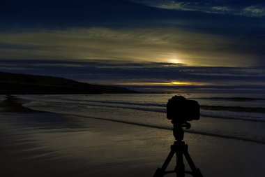 Okyanus ve arka planda günbatımı ile tripod üzerinde kamera / St Ives / Cornwall / İngiltere