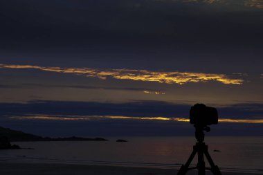 Okyanus ve arka planda günbatımı ile tripod üzerinde kamera / St Ives / Cornwall / İngiltere
