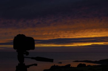Okyanus ve arka planda günbatımı ile tripod üzerinde kamera / St Ives / Cornwall / İngiltere