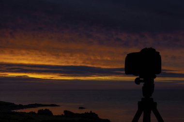 Okyanus ve arka planda günbatımı ile tripod üzerinde kamera / St Ives / Cornwall / İngiltere