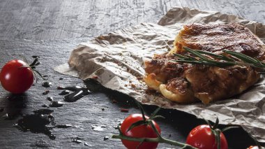 Izgara sığır eti biftek biberiye ve domates mazisi üzerinde kurulu. Arka ışık. Yakın çekim.