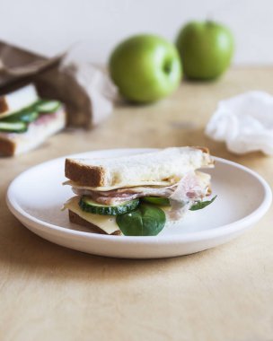 Okul kahvaltı beyaz masanın üzerinde. Sandviç ve yeşil elma