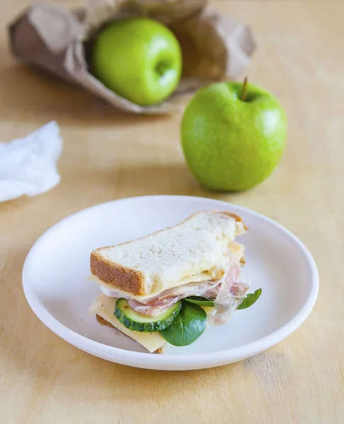 Reggeli iskola a fehér asztal. Szendvicsek és a zöld alma. — Stock Fotó