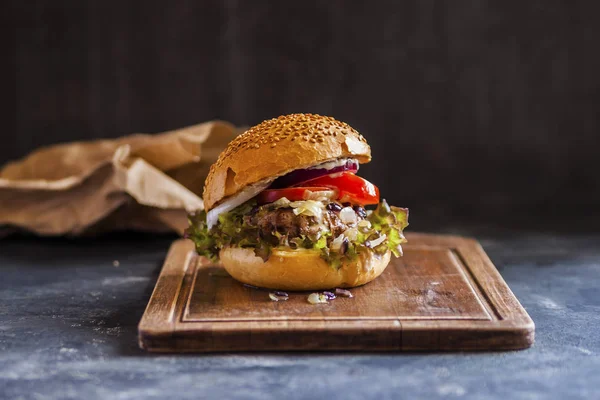 Étvágygerjesztő hamburger Patty, szósz, hagyma, saláta marhahússal. — Stock Fotó