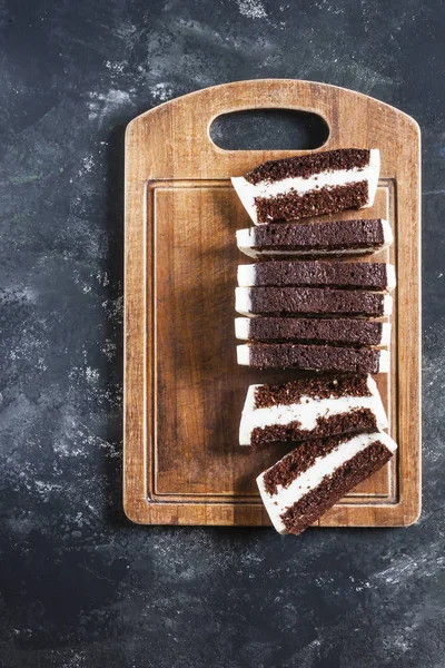 Recipe diet cake on a wooden Board, cut into pieces. Vertical. Top view.