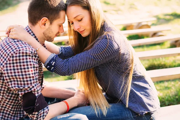 Pěkný pár těší své pocity, zatímco sedí na lavičce — Stock fotografie